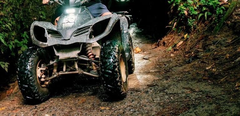 Off road adventure with ATV on narrow muddy adventure. The tire is wet because of the muddy road, give you some kick of adrenaline while riding it